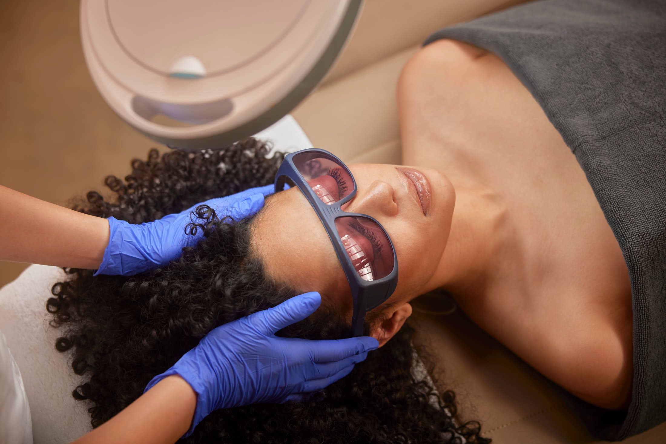 Huidtherapeut behandelt client met laser voor een lasertherapie behandelingbij the Body Clinic