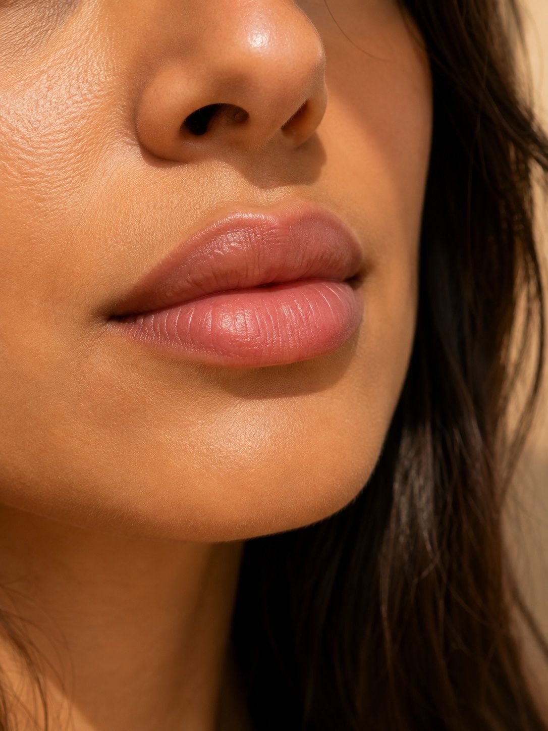 Close-up of a person's mouth and nose, showing full, naturally colored lips.