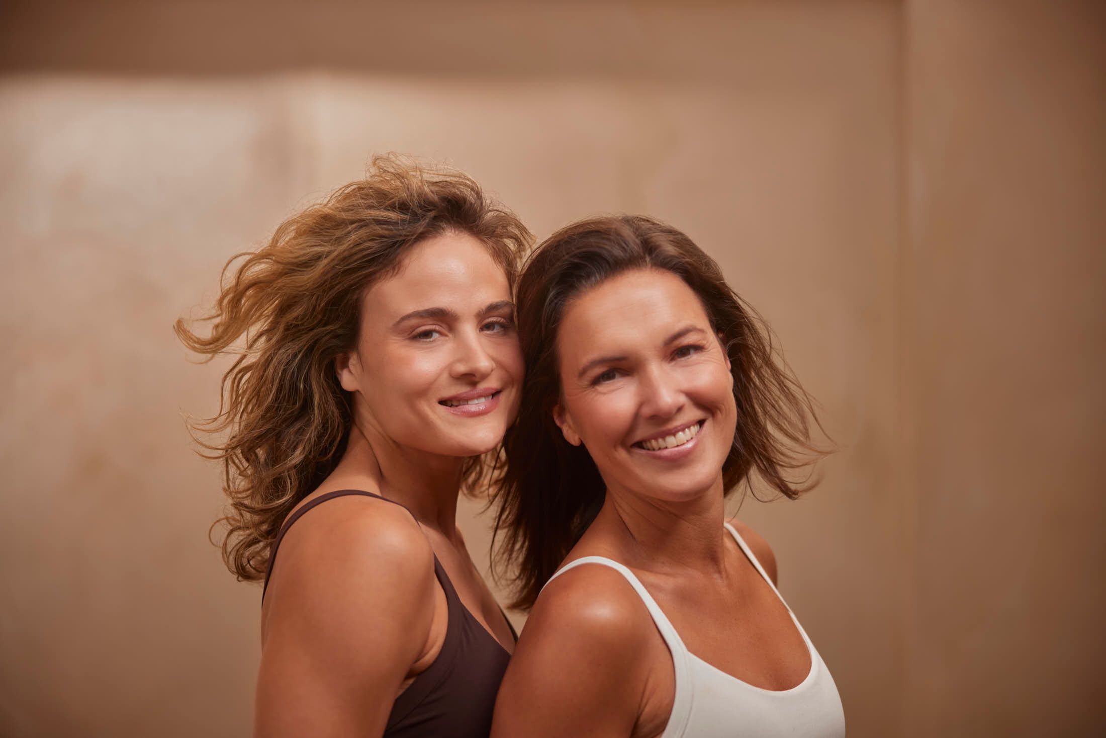 Twee vrouwen met een stralende, verzorgde huid poseren samen bij The Body Clinic