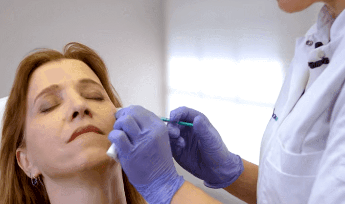 Cosmetisch arts legt fillerbehandeling voor wallen en traangoot uit in instructievideo bij The Body Clinic
