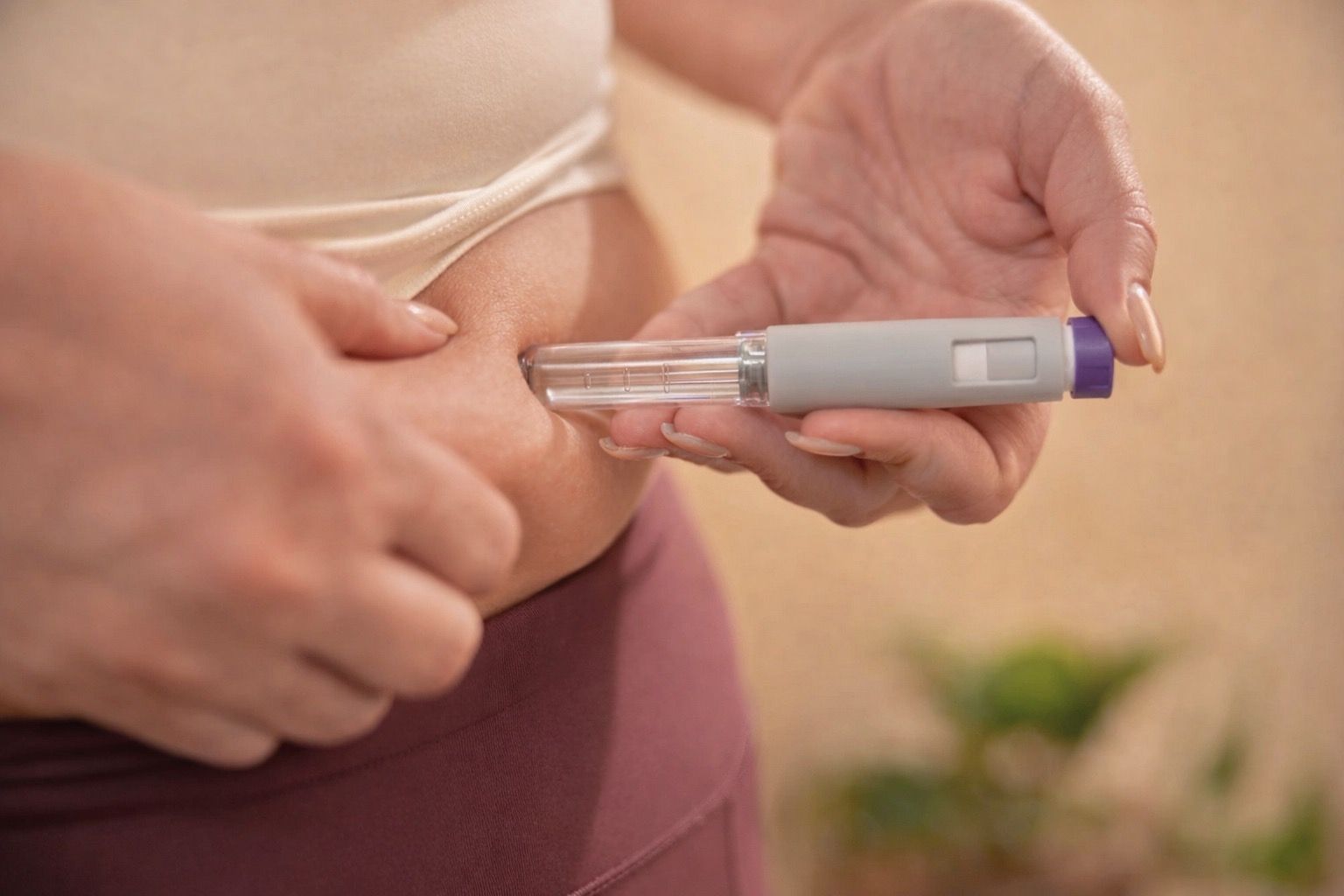 Person self-injecting insulin into their abdomen with a medical pen.