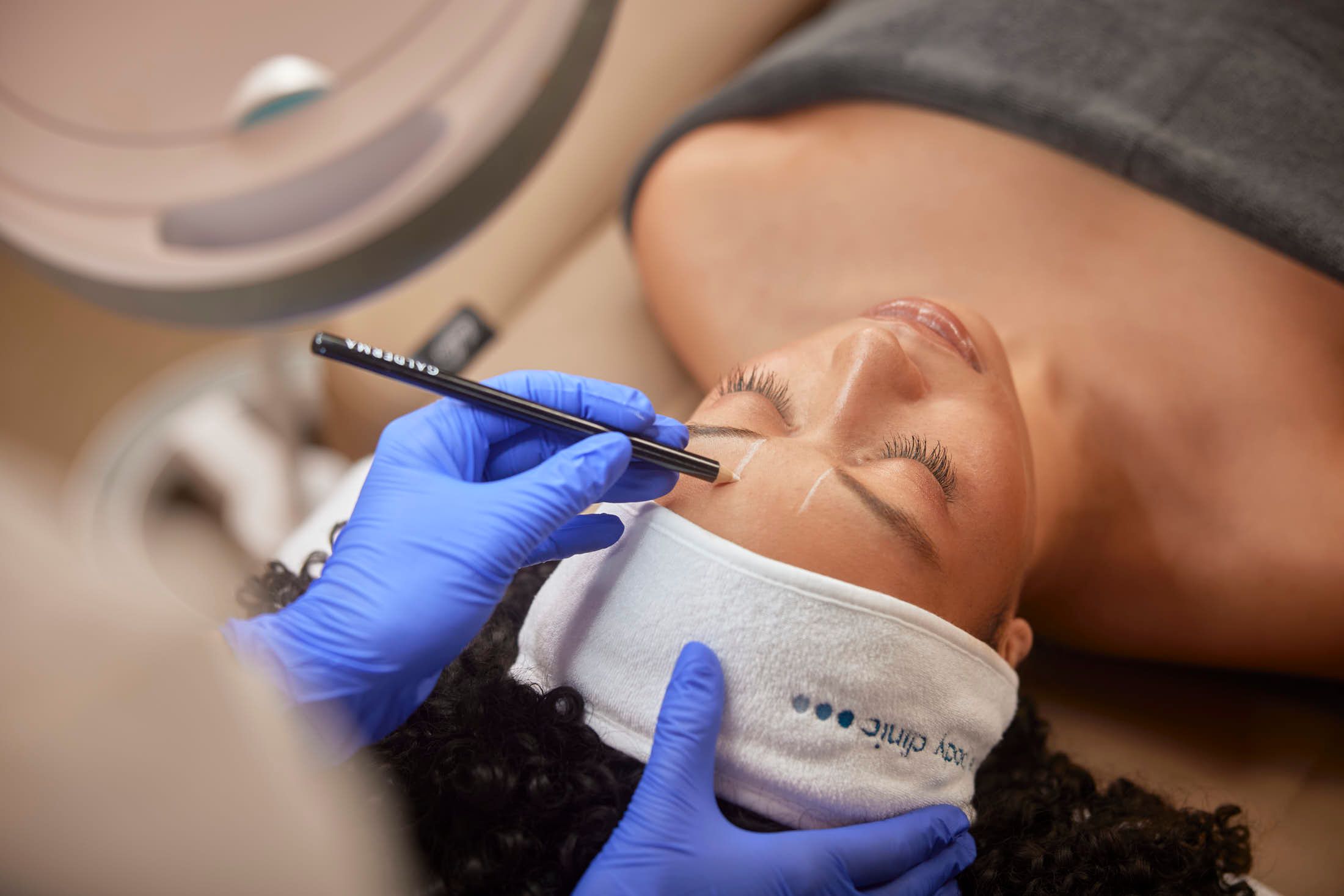 Cosmetisch arts voert precisiewerk uit op het gezicht van een client bij The Body Clinic