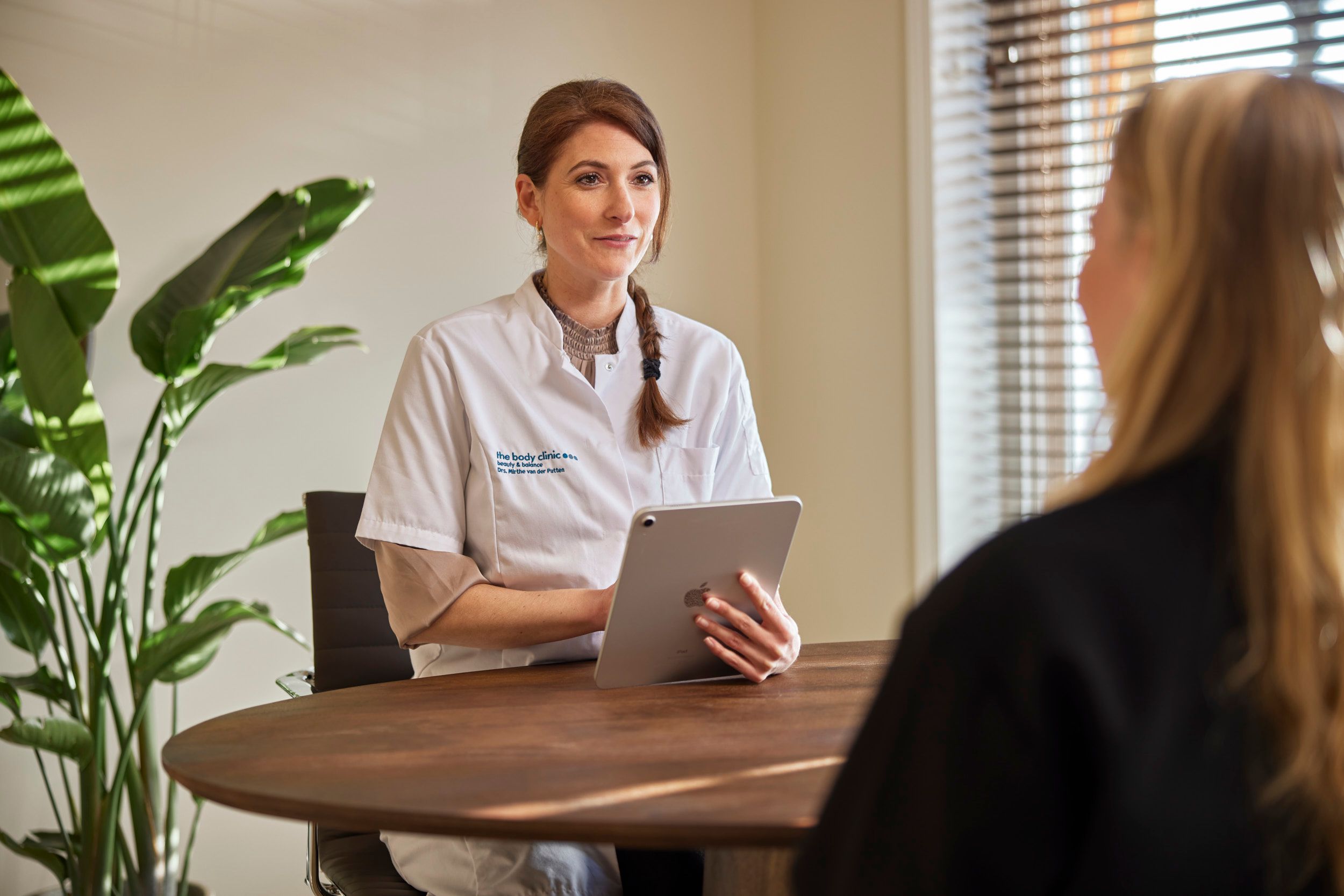 Arts en client tijdens vrijblijvend consult over kaaklijnbehandeling bij The Body Clinic