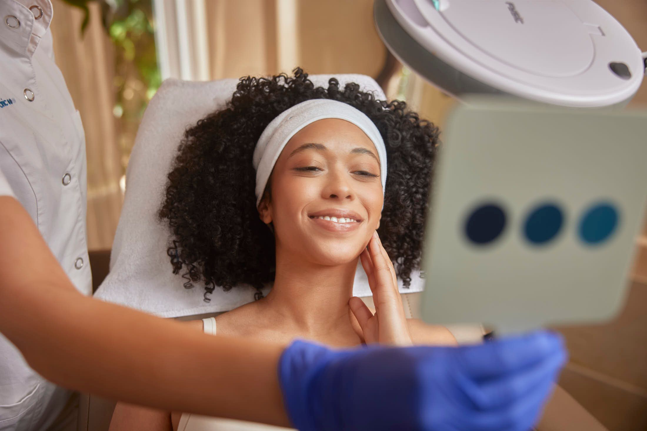 Client bekijkt huid in spiegel tijdens consult voor lasertherapie tegen pigmentvlekken bij The Body Clinic