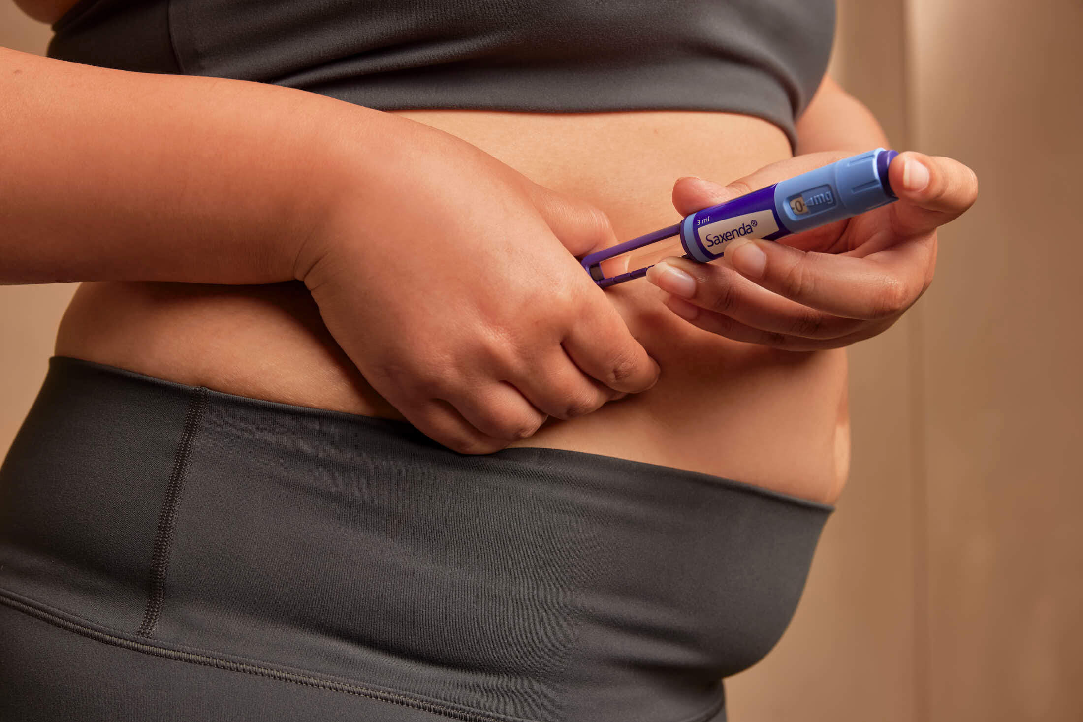 Person injecting insulin into their abdomen with an insulin pen.