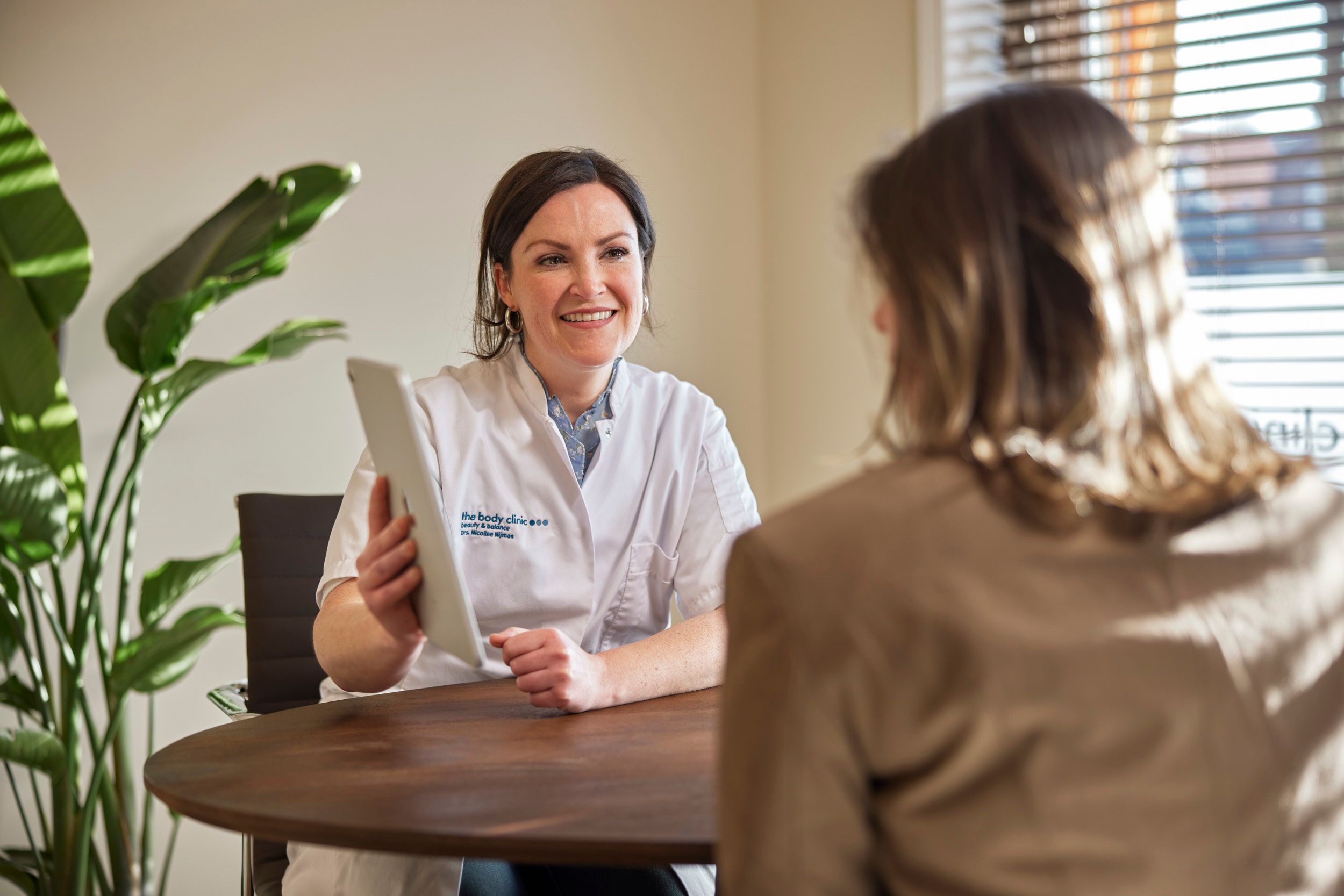 Cosmetisch arts in gesprek met client tijdens een vrijblijvend consult bij The Body Clinic