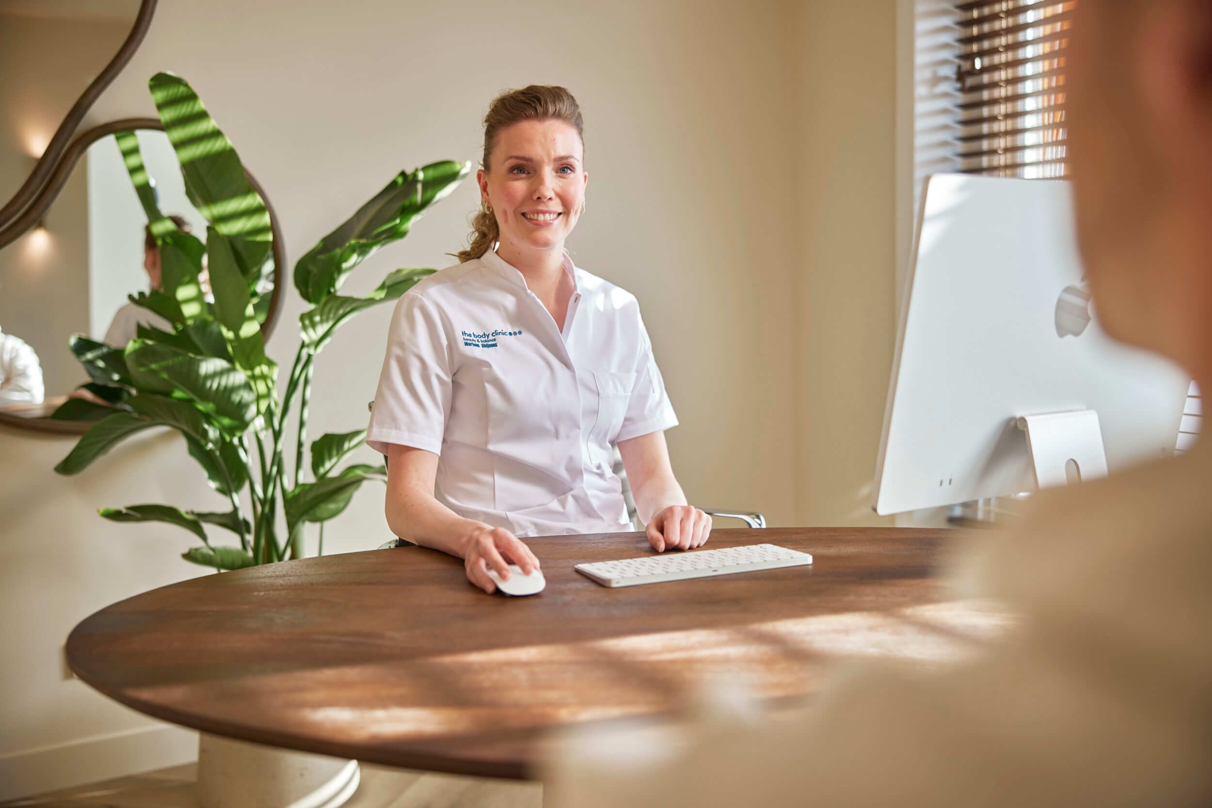 Cosmetisch arts Marleen verwelkomt cliënt voor vrijblijvend consult bij The Body Clinic