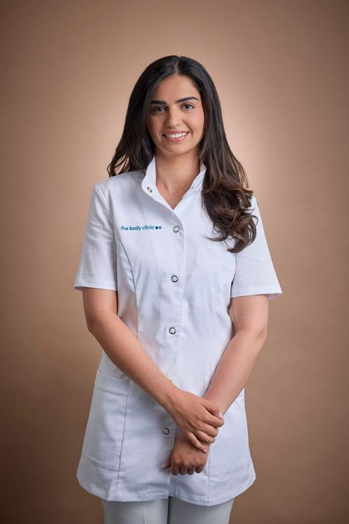 Dr. Shreya Shah, a dental surgeon, smiles confidently in her white lab coat.