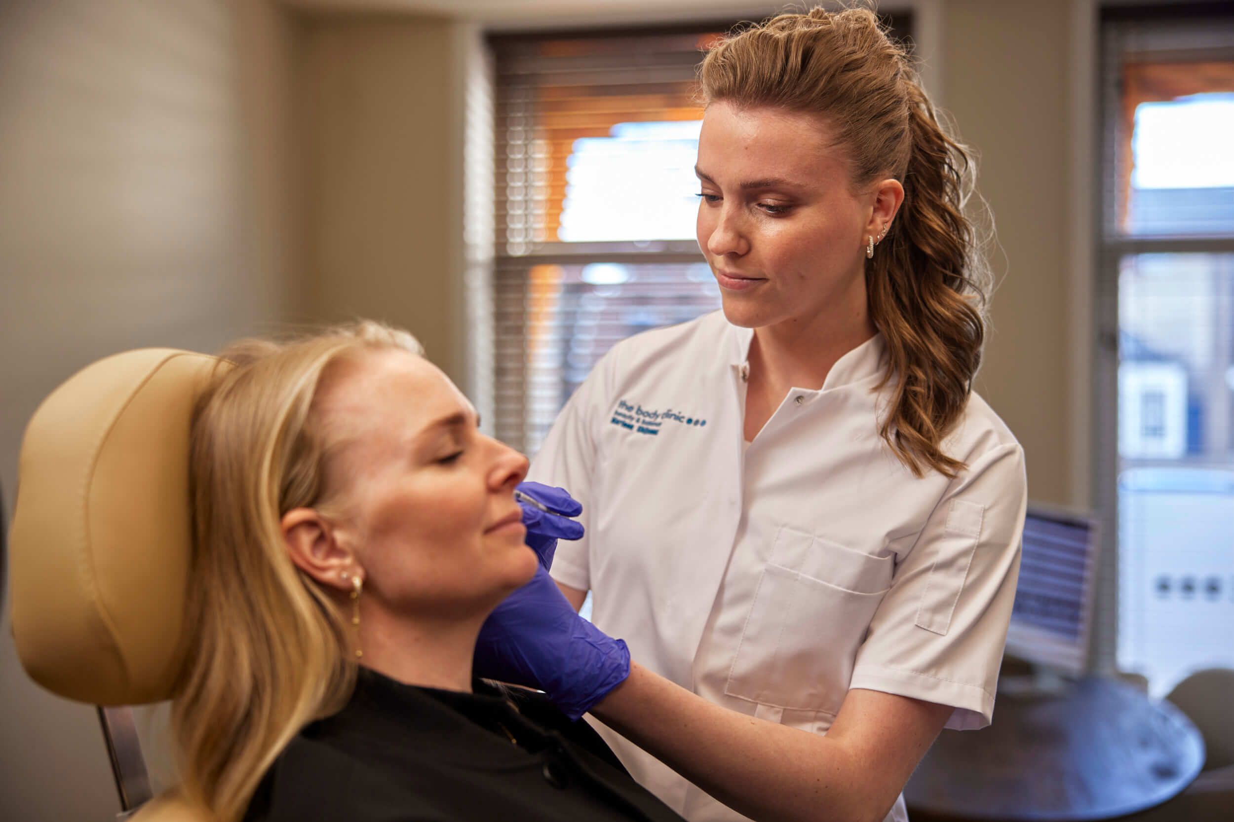 Huidtherapeut voert een Rejuran skinbooster behandeling uit met micro-injecties in het gezicht bij The Body Clinic