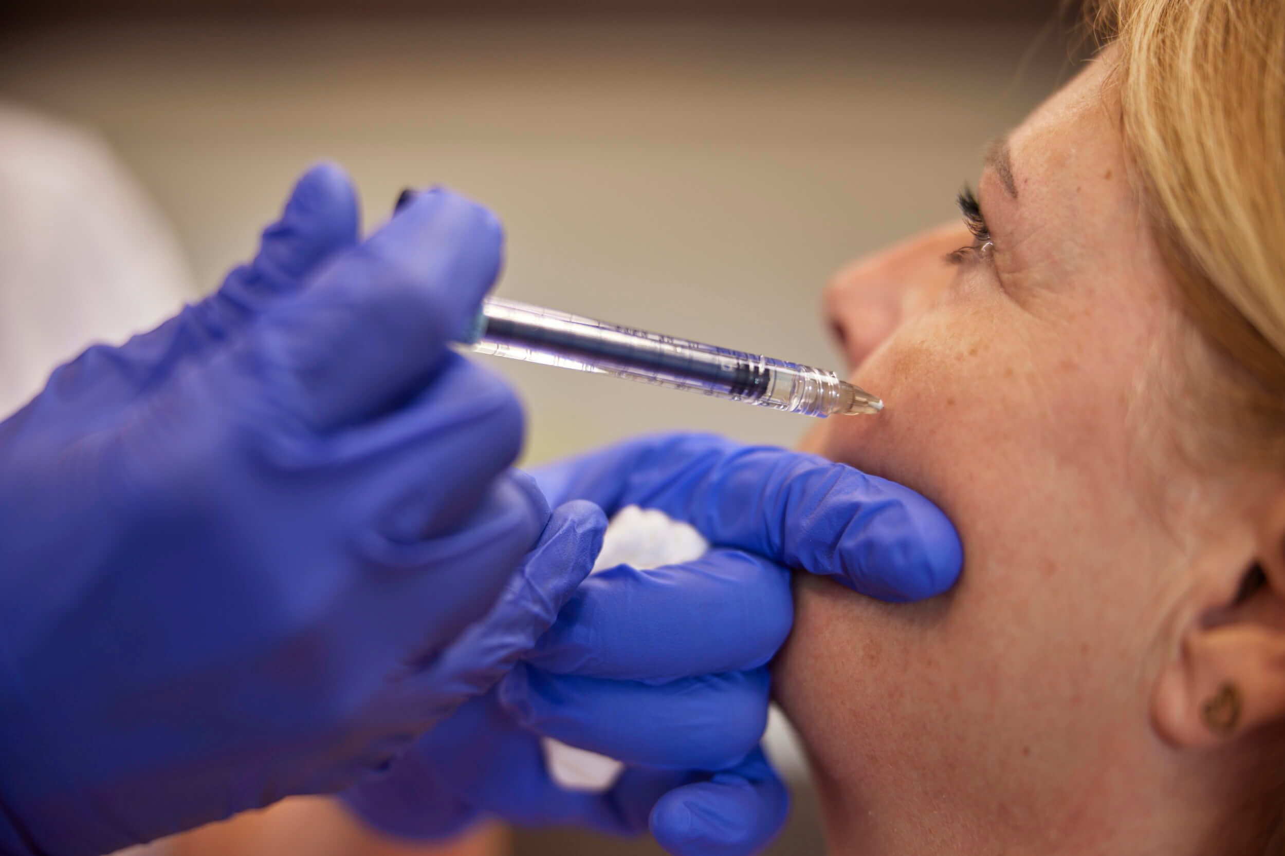 Arts injecteert filler in wangen van client bij The Body Clinic