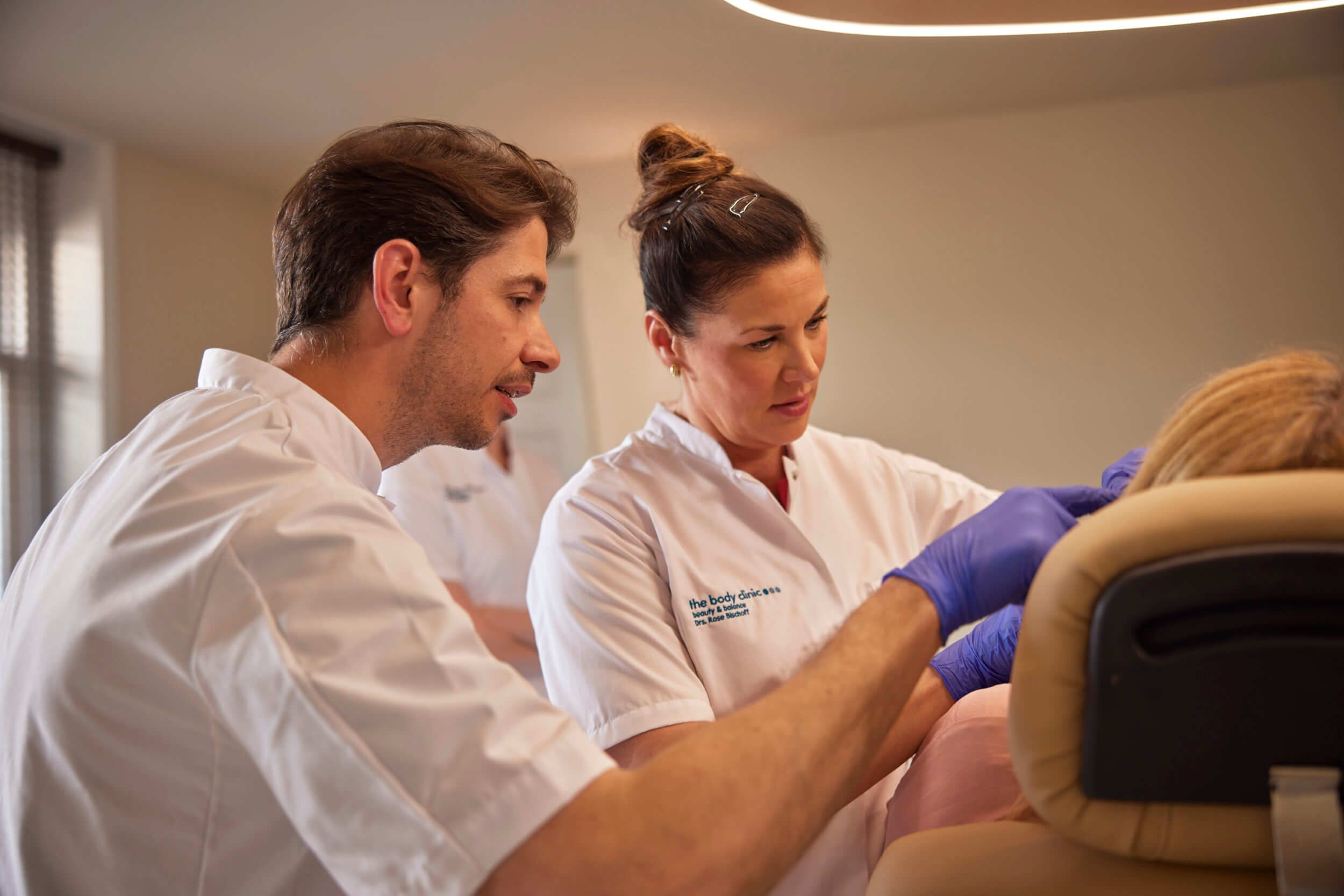 Twee cosmetisch artsen werken samen tijdens injectables behandeling bij The Body Clinic