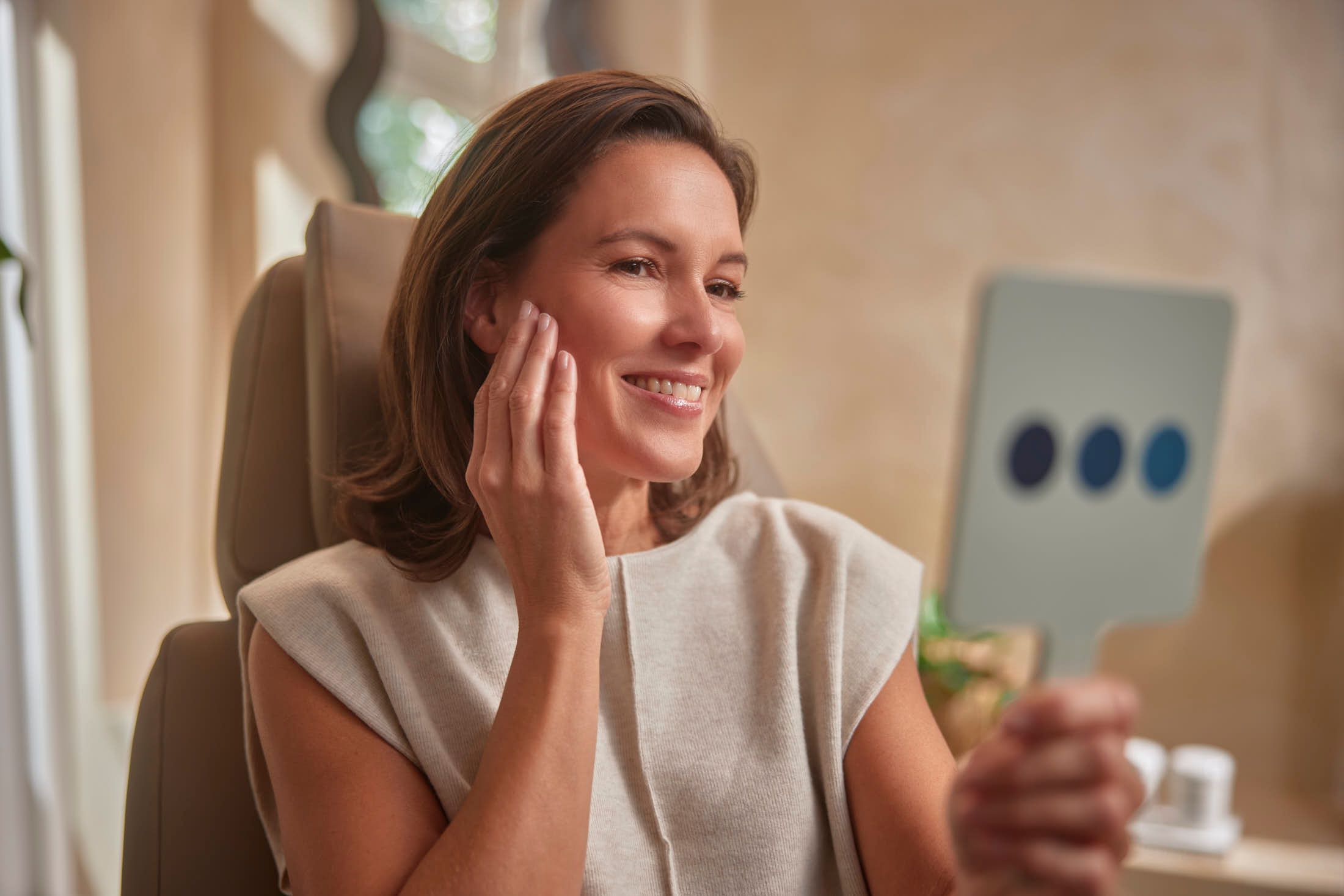 Tevreden cliënt bekijkt het resultaat in de spiegel na een cosmetische behandeling bij The Body Clinic
