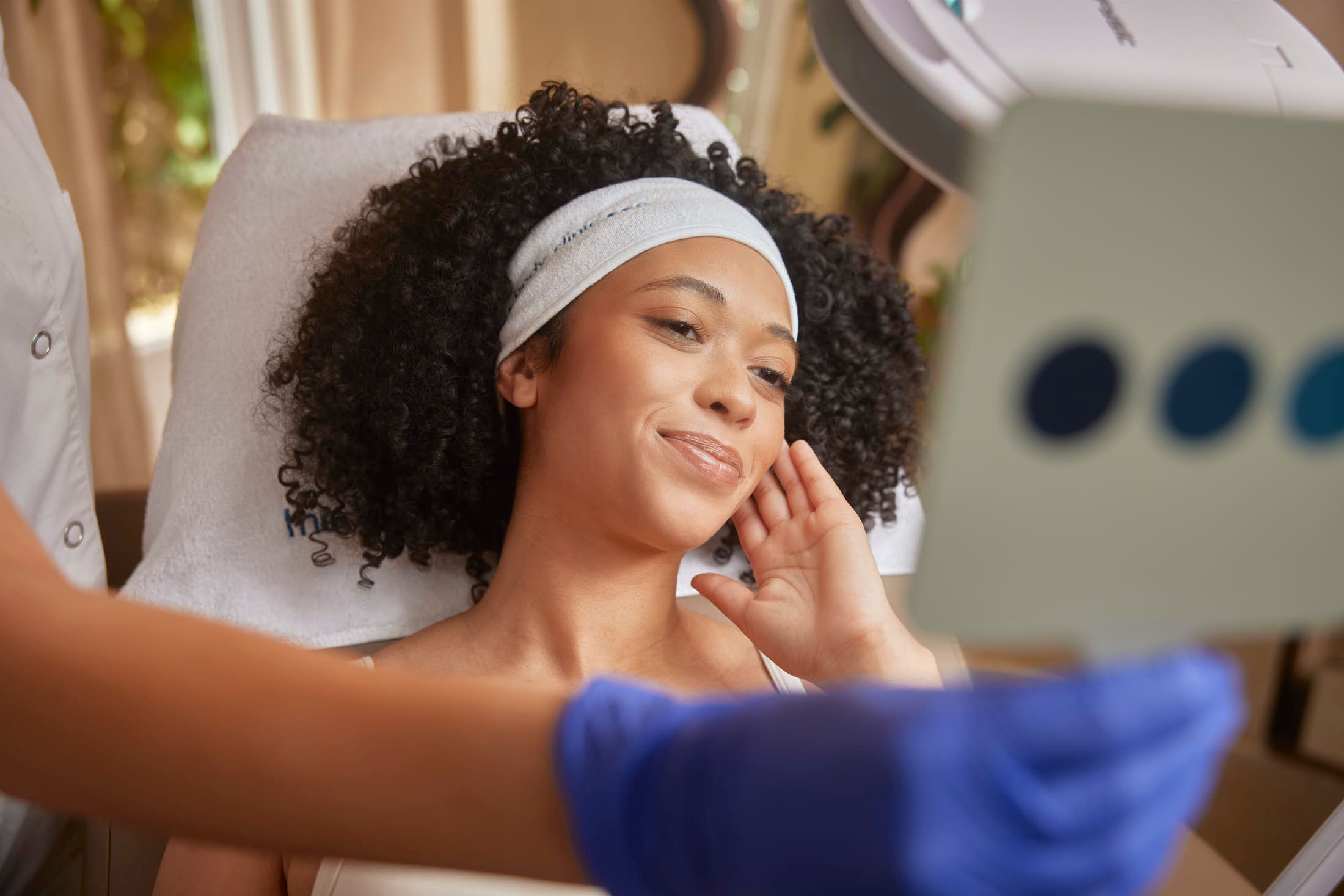 Client bekijkt glanzende huid na Mesobotox behandeling bij The Body Clinic