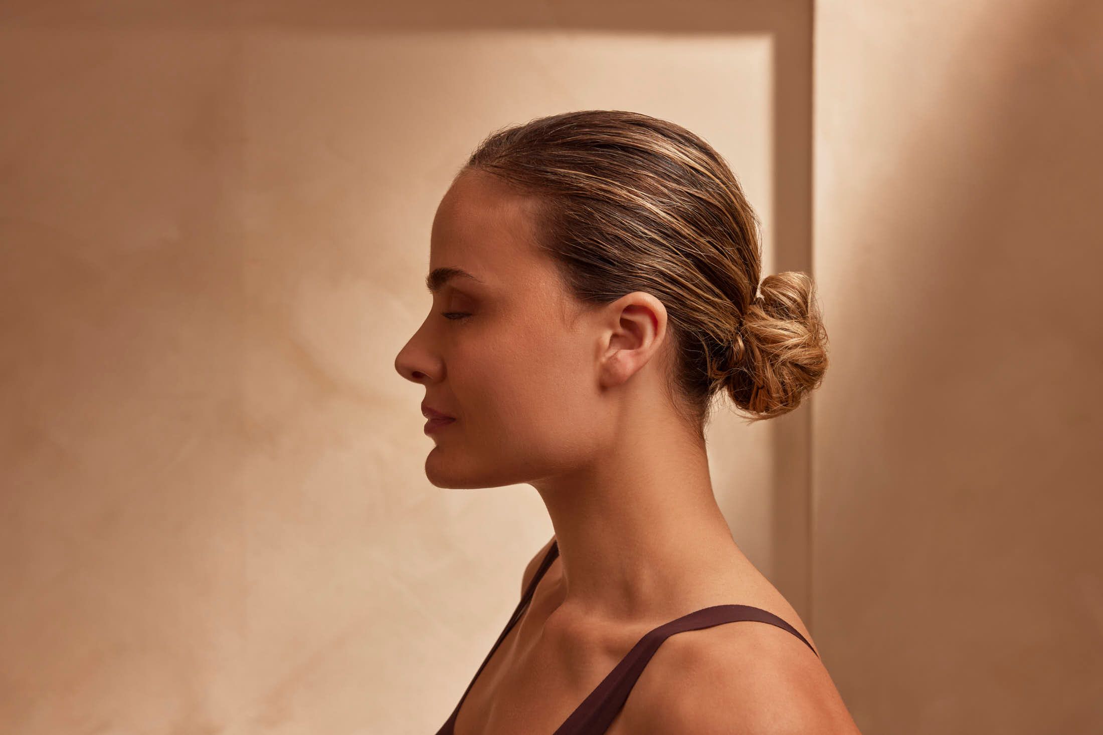 Vrouwelijke client in profiel na controleafspraak voor touch-up bij The Body Clinic