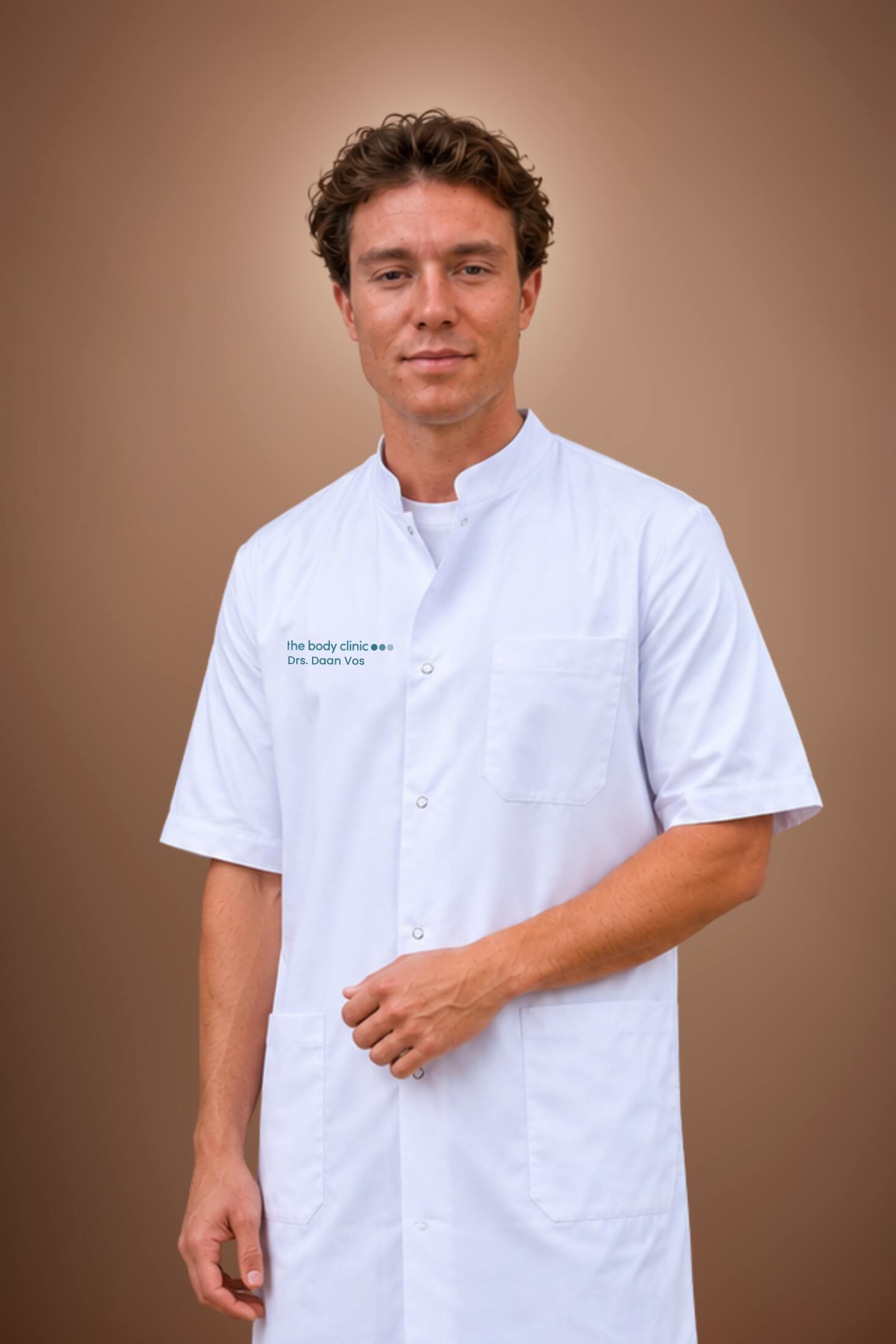 A professional man in a white medical coat stands confidently against a plain brown background.