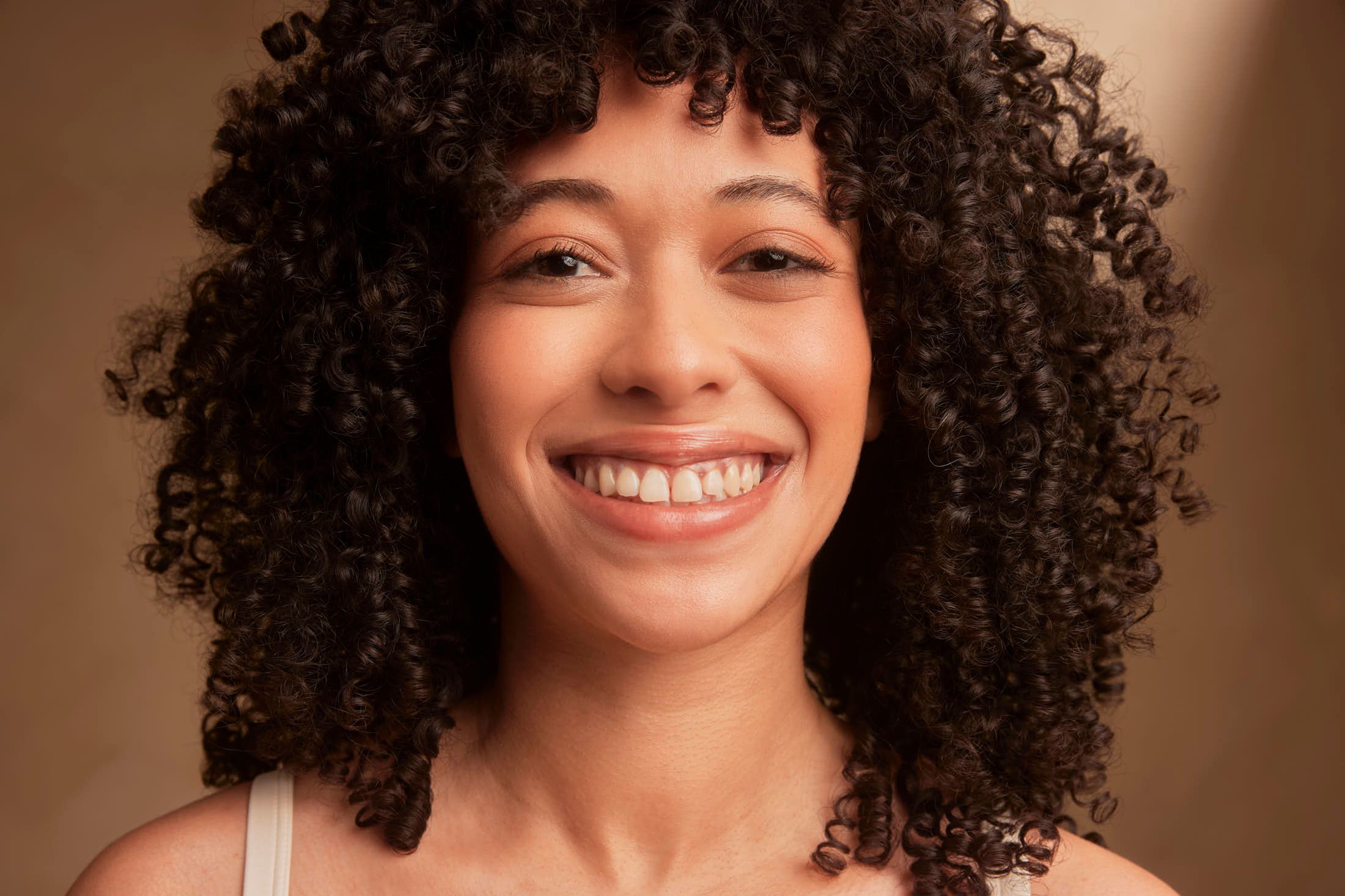 Close-up portret van een lachende vrouw met een stralende, egale huid bij The Body Clinic