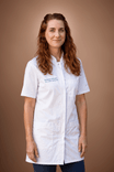 Professional woman with red hair in white lab coat smiles gently.