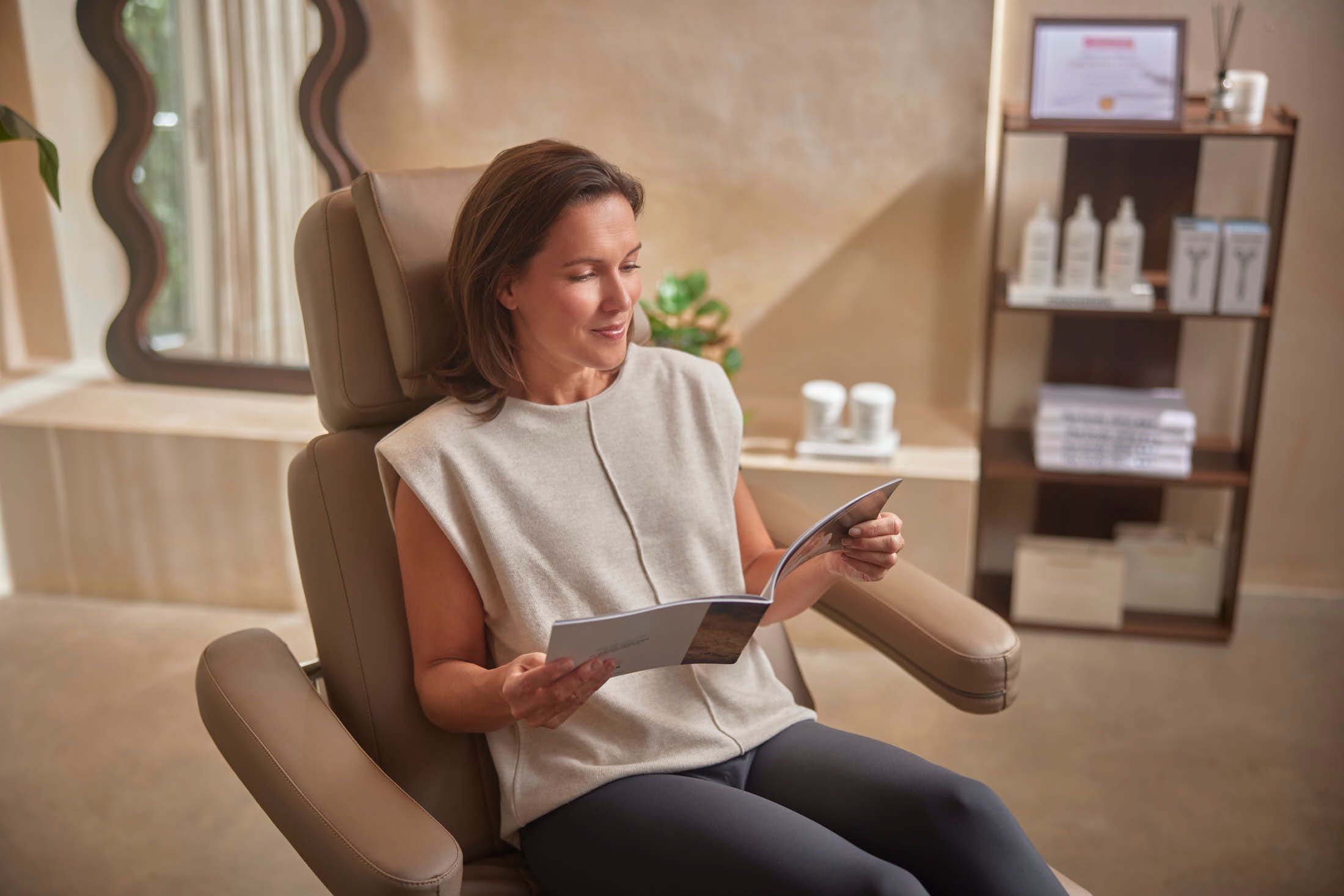 Vrouwelijke client in behandelkamer na cosmetische behandeling bij The Body Clinic